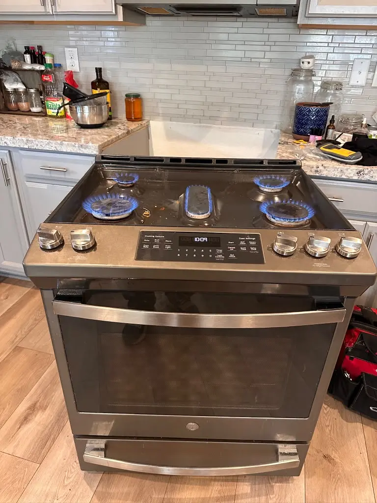 GE slide-in gas range with the burners lit