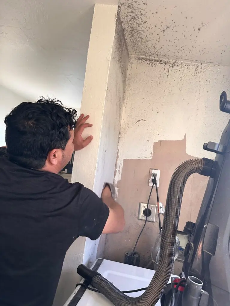 Technician working on the dryer vent hose behind a dryer