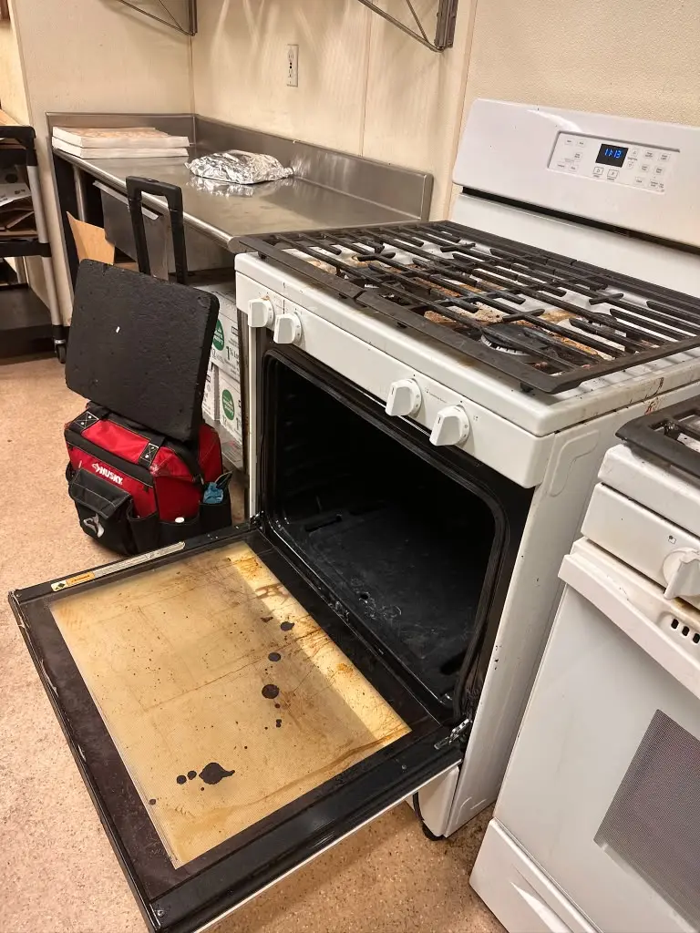 Appliance repair in sacramento: White gas range with the oven door open for repair